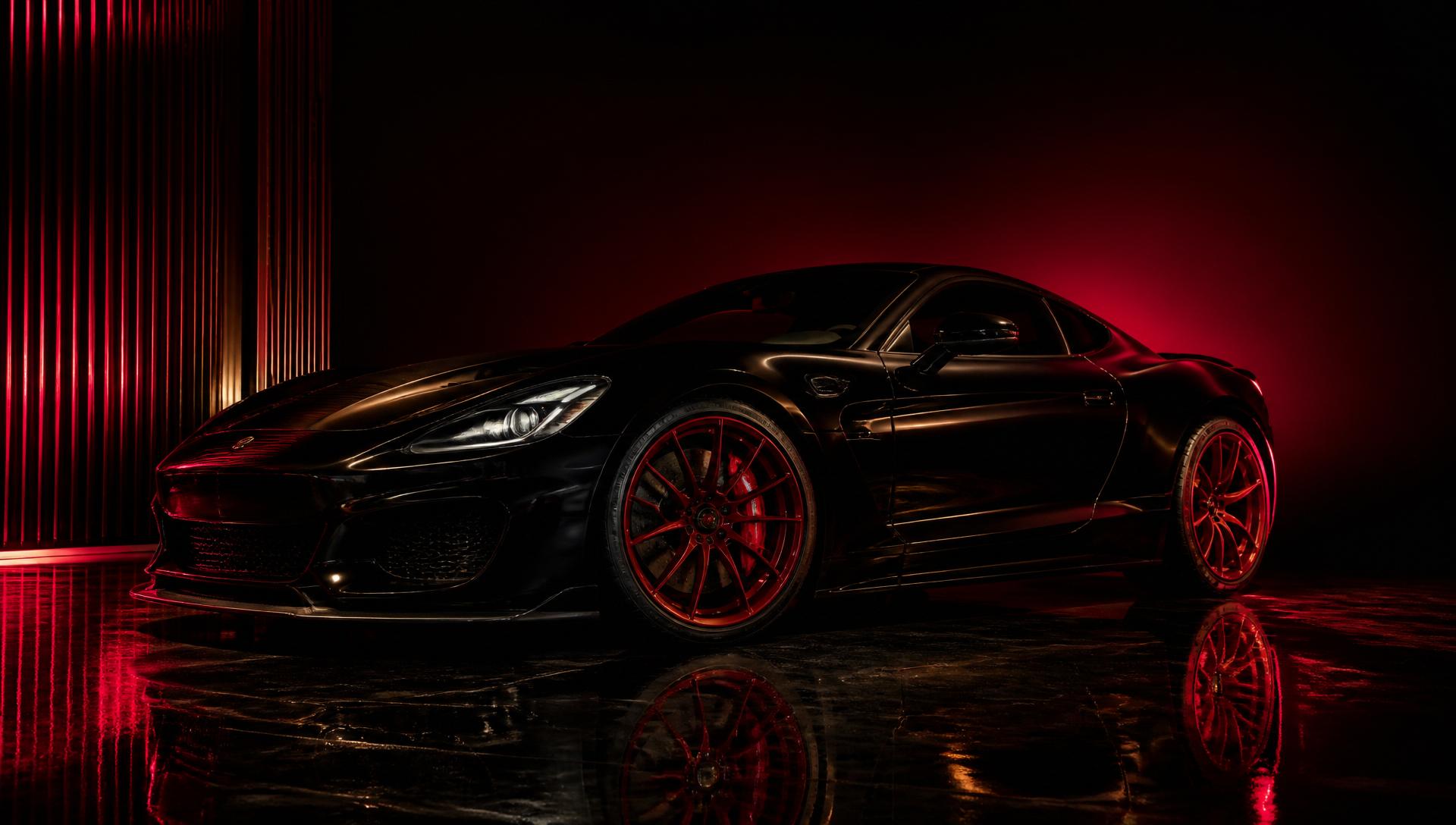 Glossy black sports car with red wheels after a VIP mobile detail, dramatic showroom lighting